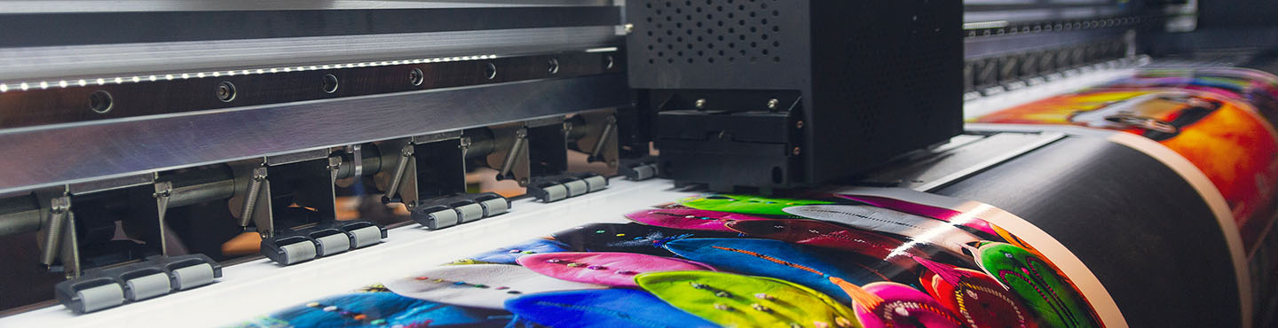 A large format printer in the process of creating a large, colourful print
