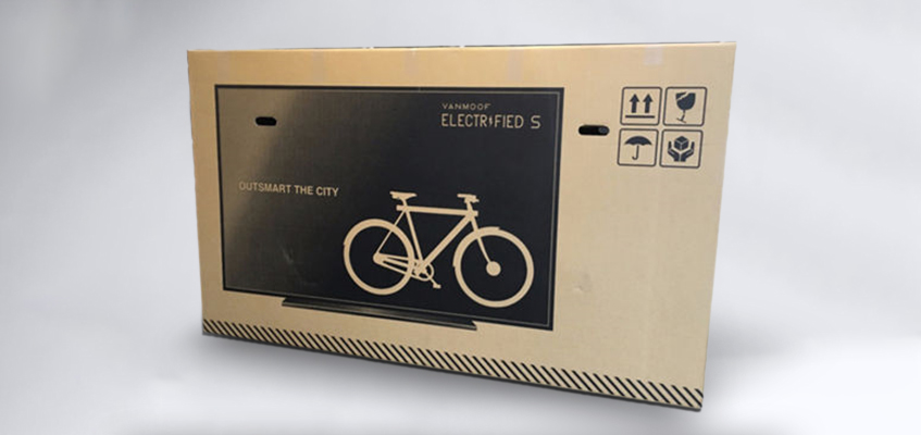 Afbeelding van een TV op een kartonnen doos met binnenin een Van Moof e-bike 