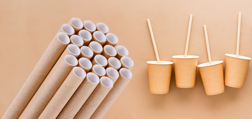 Een kartonnen doos bedrukt met ‘add to cart’ Een bundel kartonnen rietjes