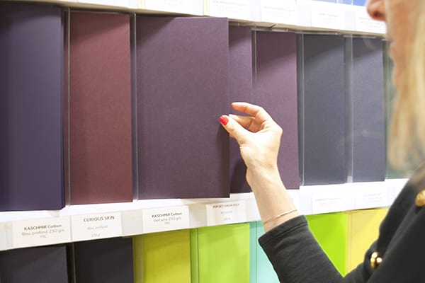 Une femme prend une feuille de papier du showroom Antalis