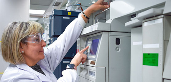 lab expert in front of a machine testing a packaging