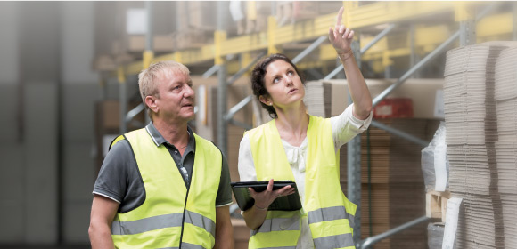 professionnels révisant le stockage dans un entrepôt