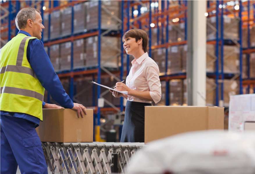 professionals talking in a warehouse in front of a packaged good